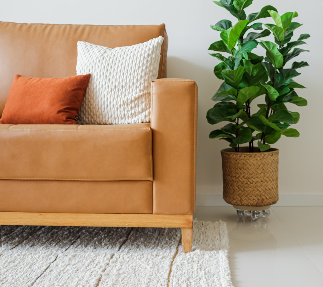 Stylish, well-lit living room with cozy borro decor and a caramel synthetic sofa. Modern comfort and ambiance.